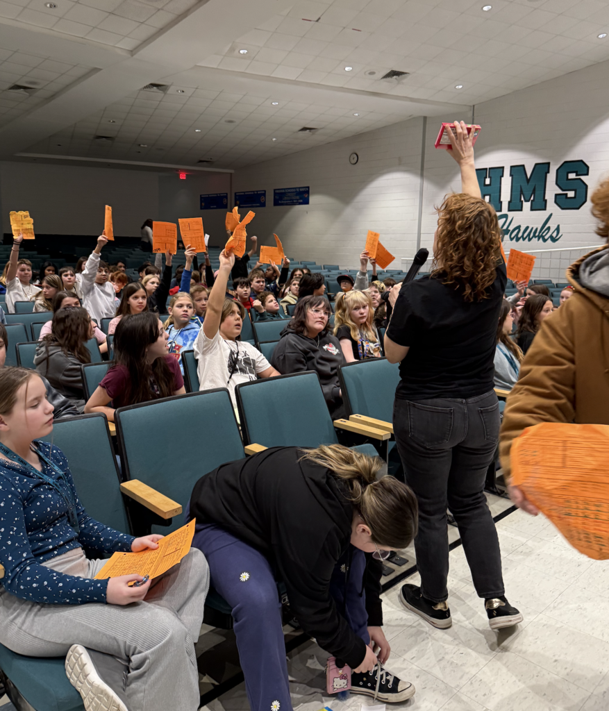 students in the auditorium for their team auction