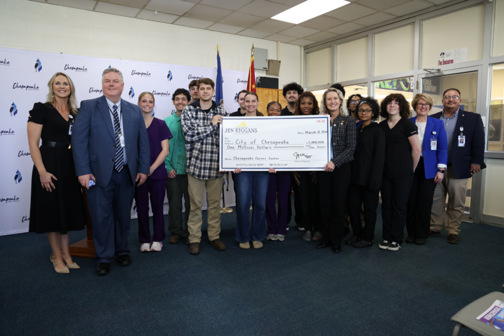 Group of studenst, leaders and Kiggins holding check.