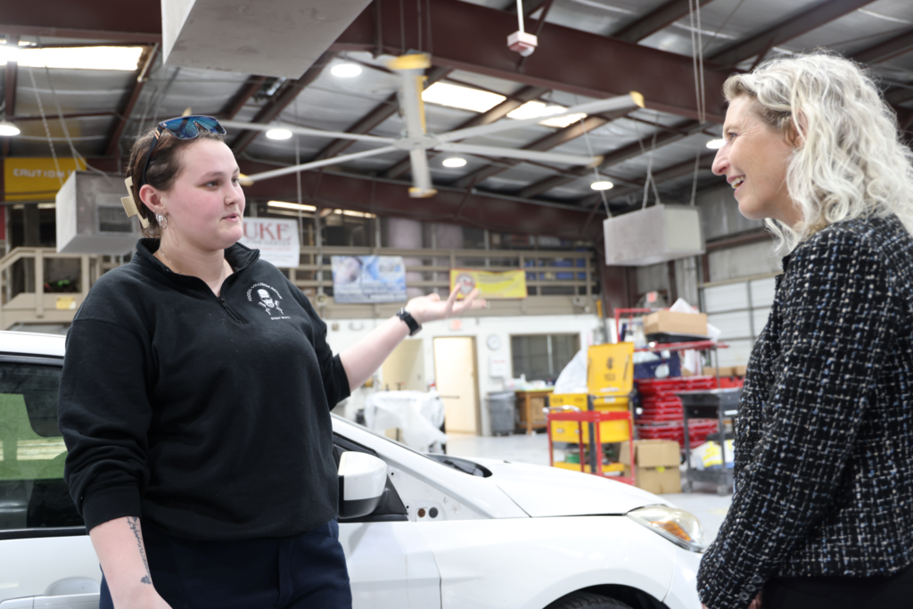 Kiggins and student talking in car shop