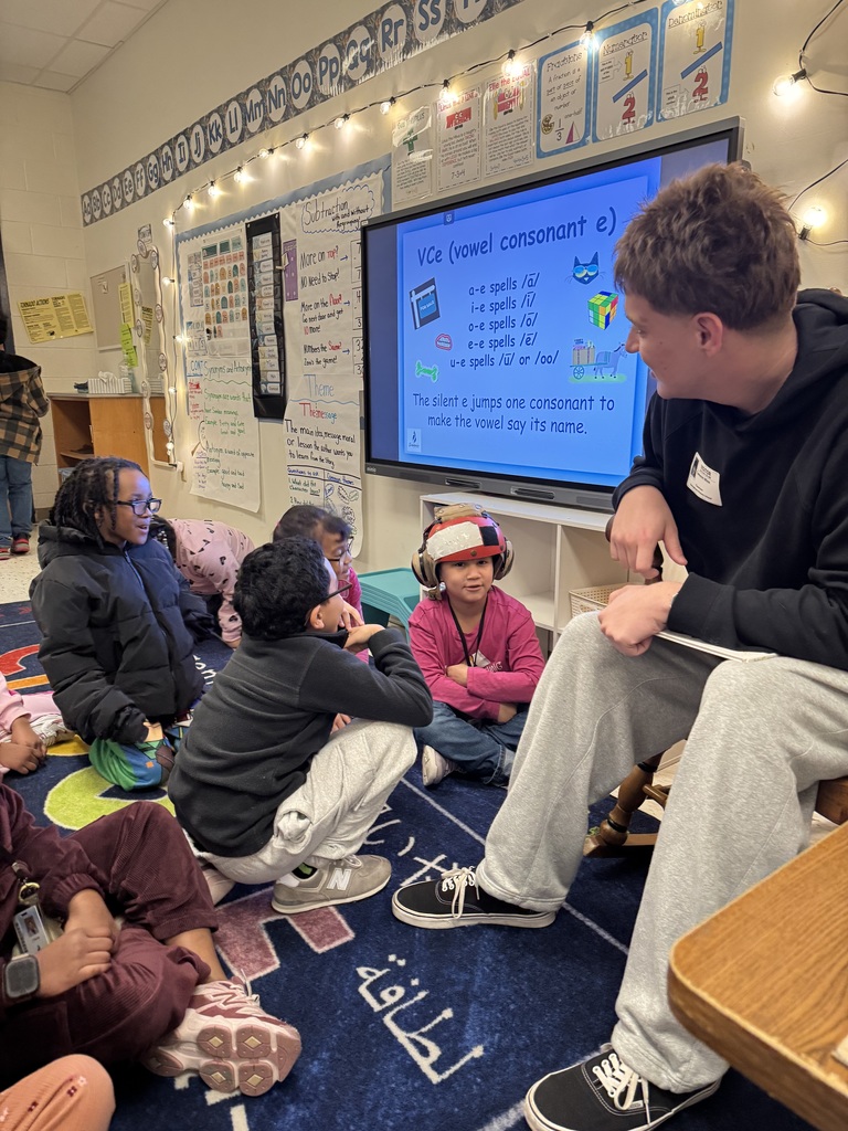 Navy Firefighter letting students wear his head gear