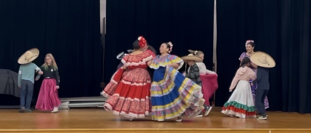 Ballet Folklorico dancing on stage with students and staff at BRI