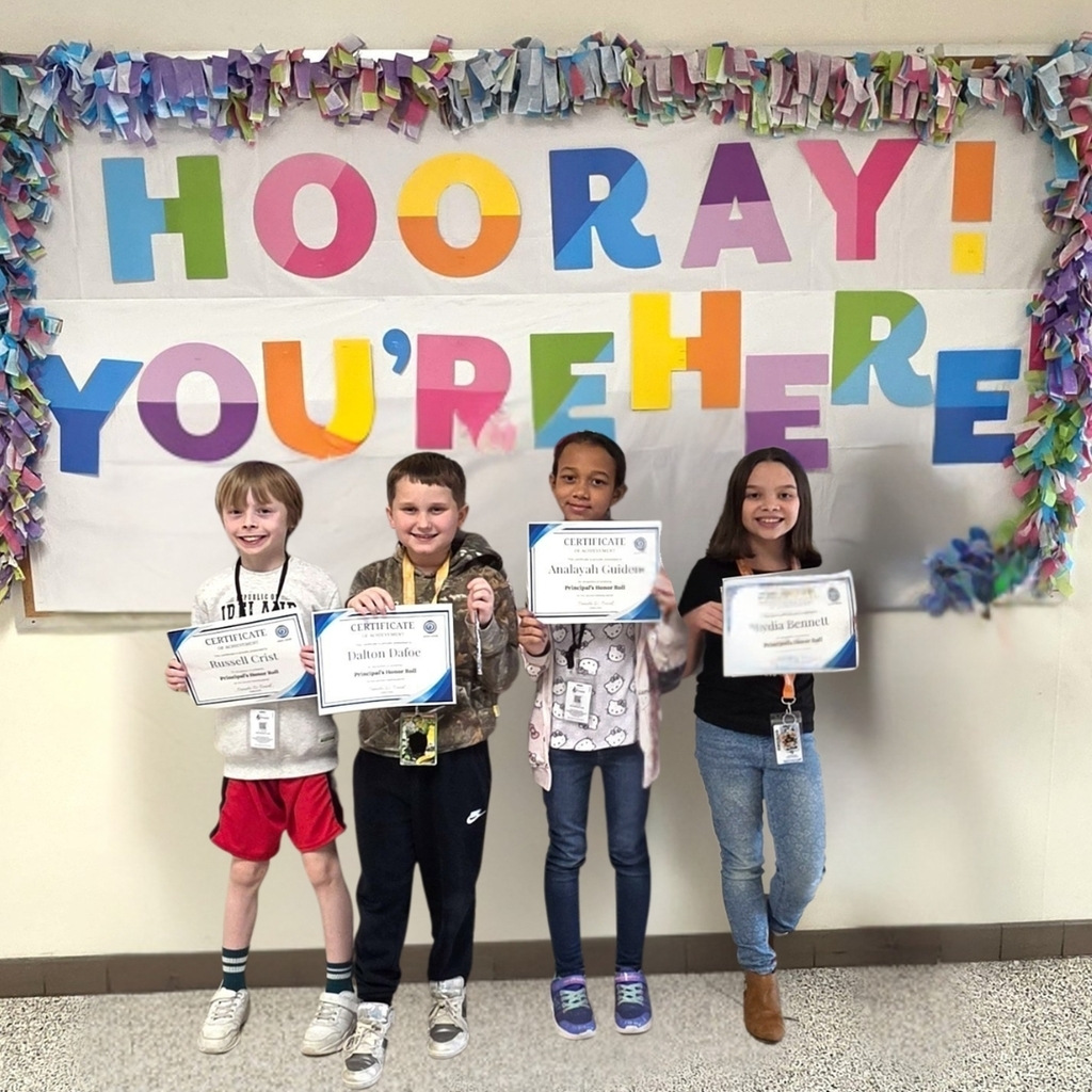3rd grade students standing together and posing to show their honor roll certificates