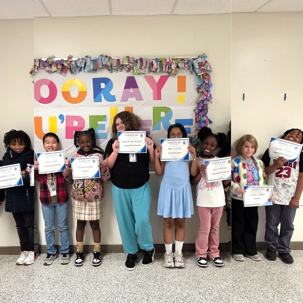 3rd grade students standing together and posing to show their honor roll certificates
