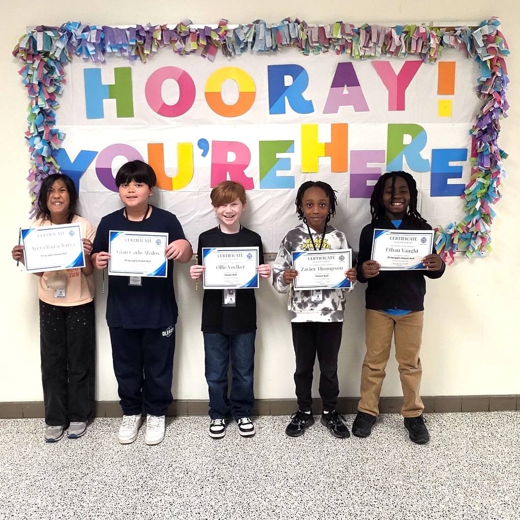 3rd grade students standing together and posing to show their honor roll certificates