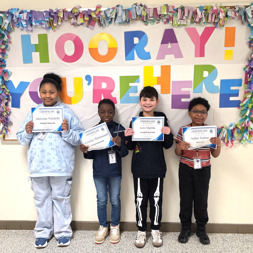 3rd grade students standing together and posing to show their honor roll certificates