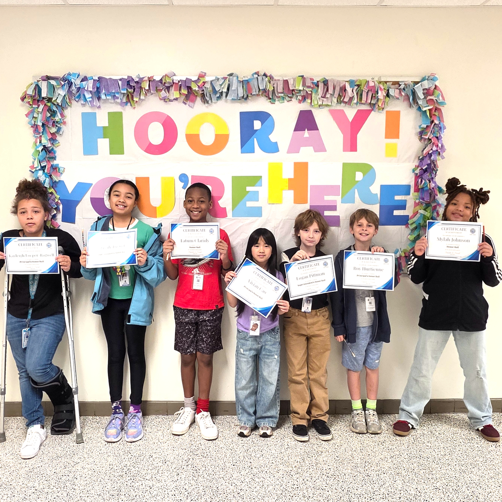 3rd grade students standing together and posing to show their honor roll certificates