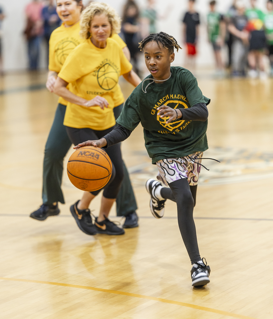 Student driving the ball down the court