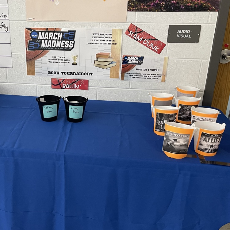 March Madness book vote: colorful buckets on a table for students to cast their votes.