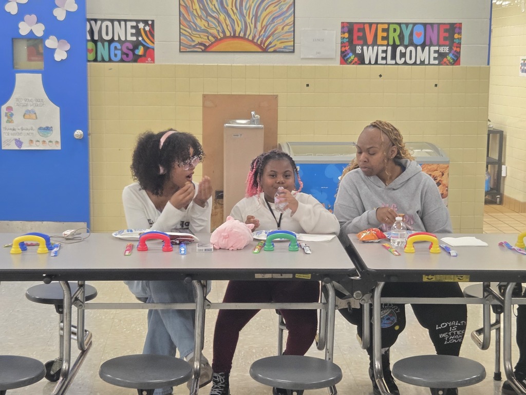 Family eat pizza in lunch room.