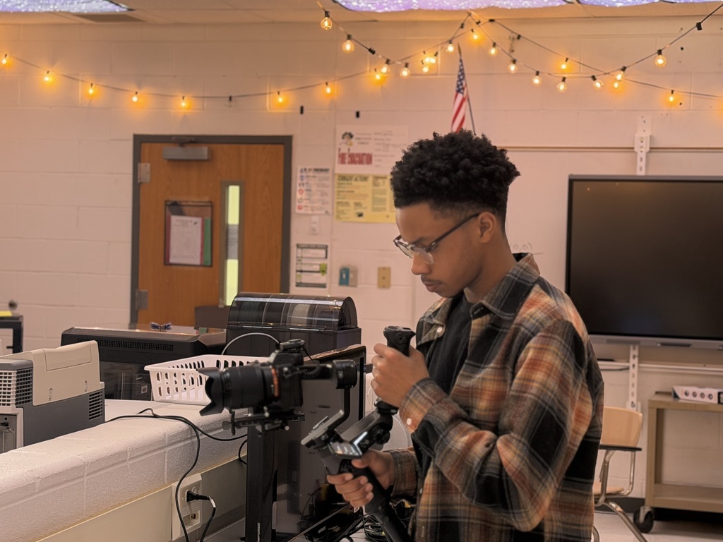 student concentrating while capturing an interview on his camera