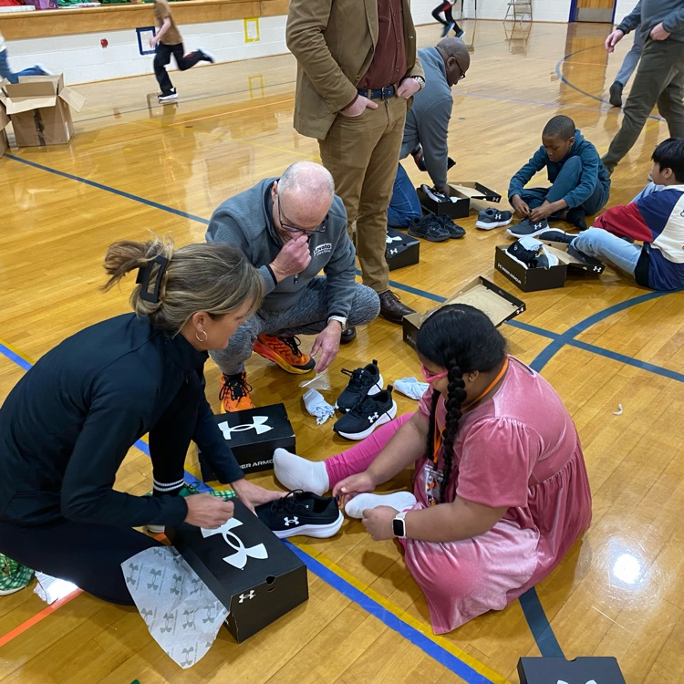 students and sponsors focused on trying on their new sneakers 