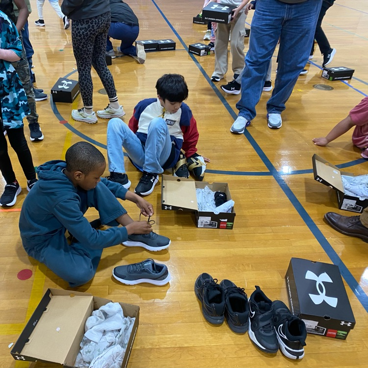 students focusing on trying their new sneakers on