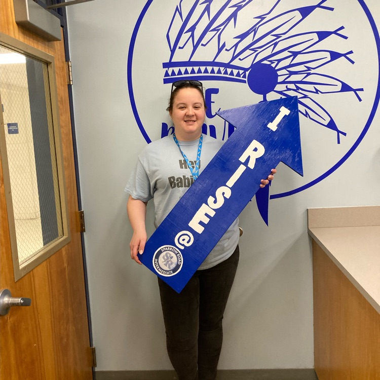 Mrs. Jarvis proudly holding the I RISE arrow. 