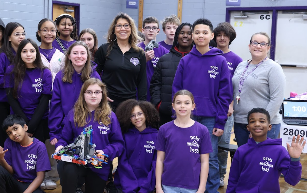 Mrs. Surratt posing with her students after a robotics tournament.