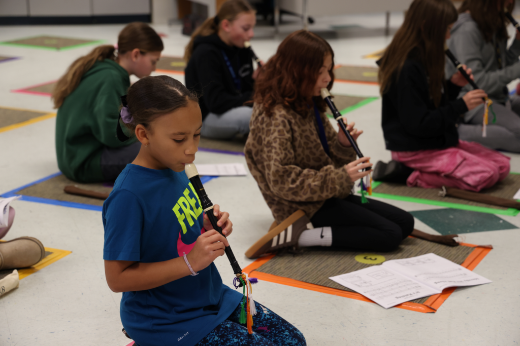 student focusing on practicing her recorder