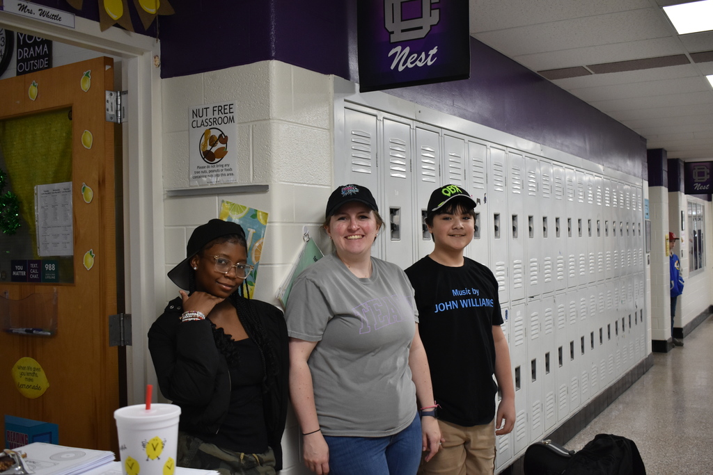A teacher and two students wearing a their favorite hats for reading month. 