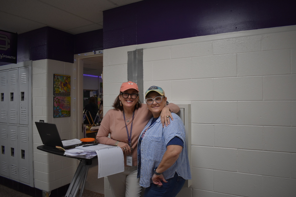 two teachers wearing their favorite hats for reading month. 