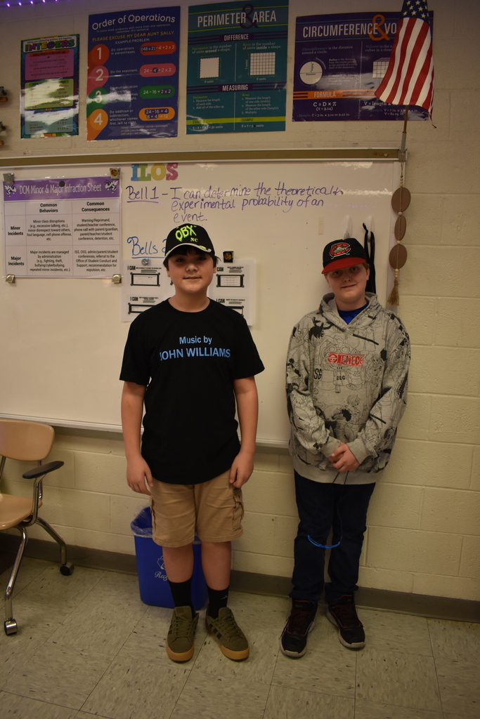 Two students wearing their favorite hats for spirit week.