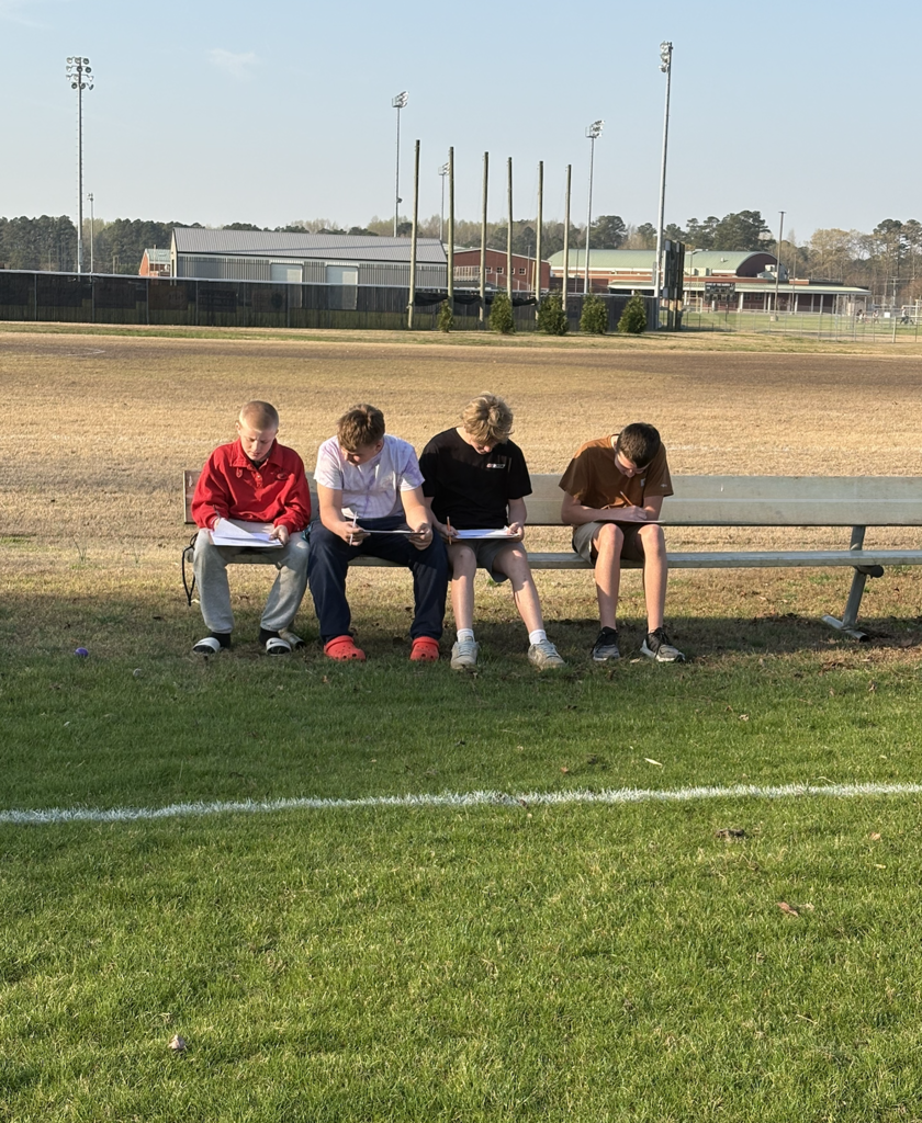 students collaboratively working outside to discover plastic eggs with math problems inside