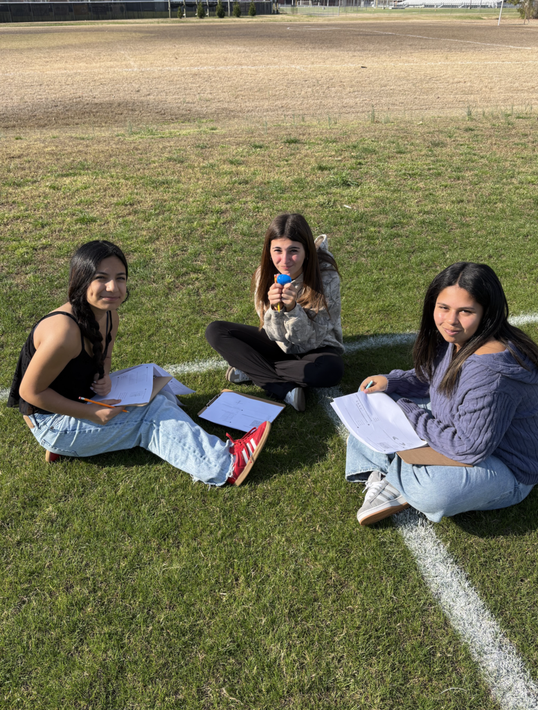 students collaboratively working outside to discover plastic eggs with math problems inside