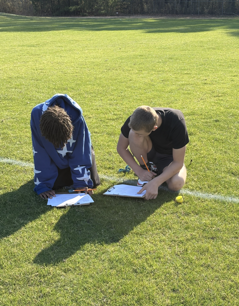 students collaboratively working outside to discover plastic eggs with math problems inside