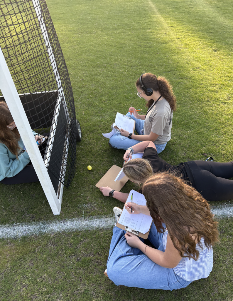 students collaboratively working outside to discover plastic eggs with math problems inside