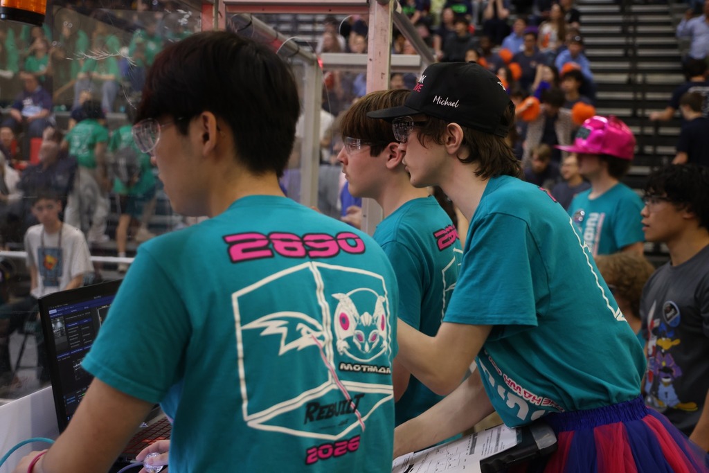Three HHS Robotics team members controlling the robot during the competition.