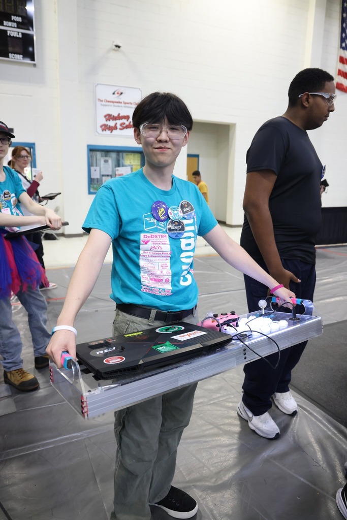 A HHS Robotics team member holding the computer and controller.