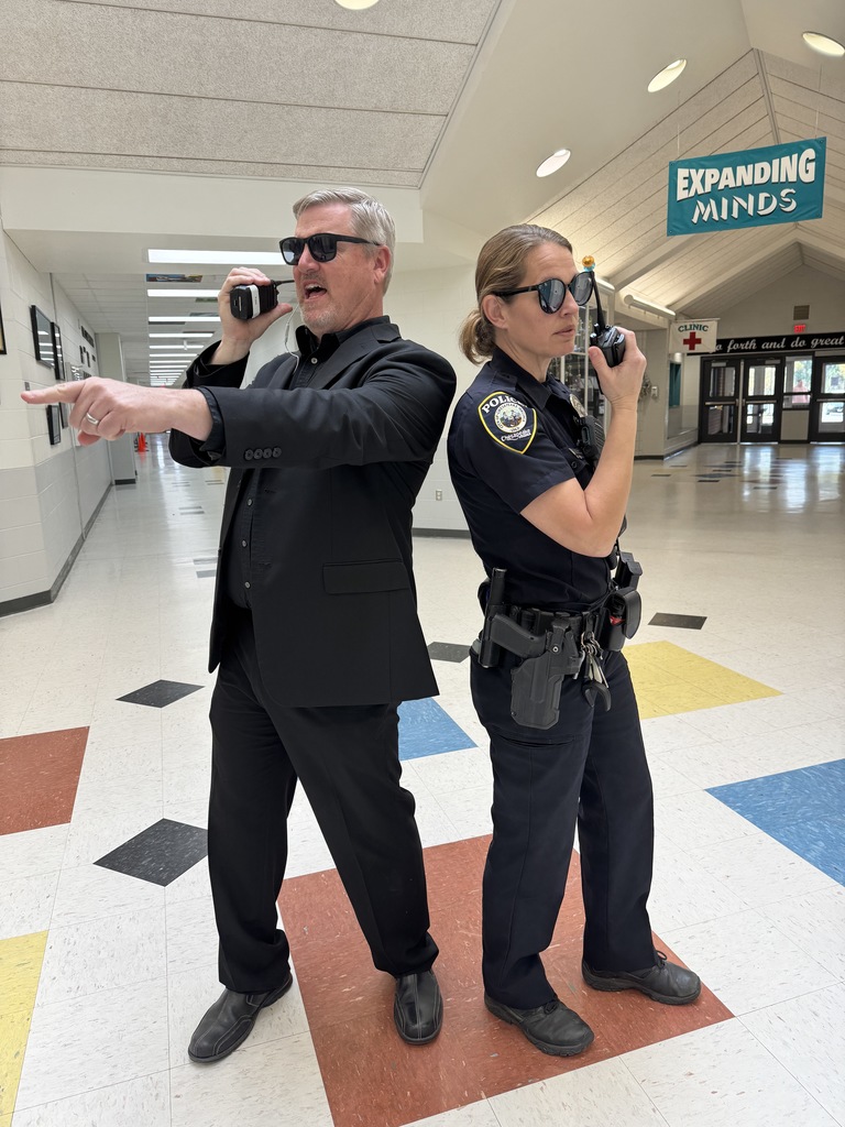 Prinicpal and School Resource Officers showing off their secret agent skills with walkies in hand