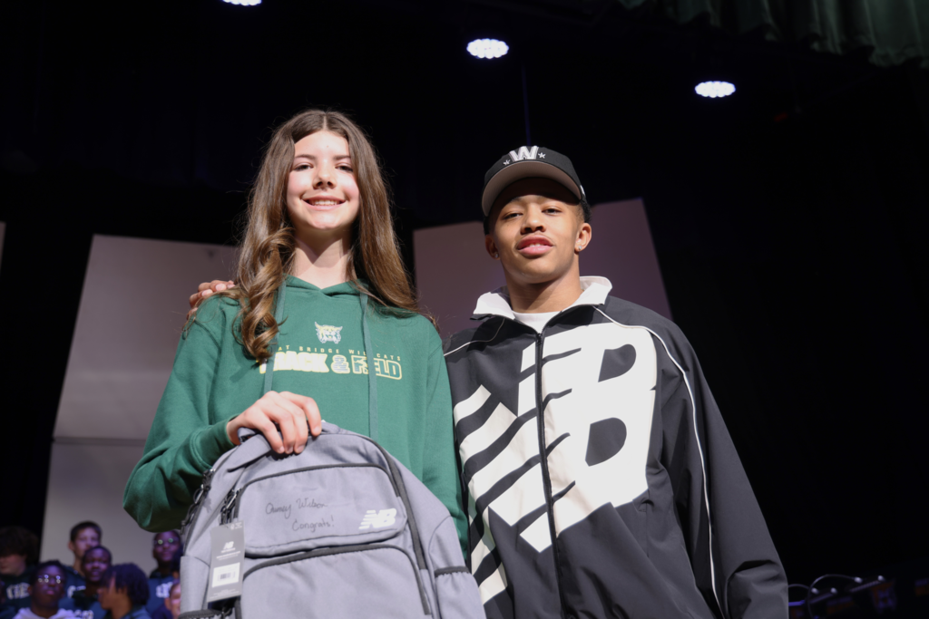 after winning a backpack a student excitedly poses with Quincy