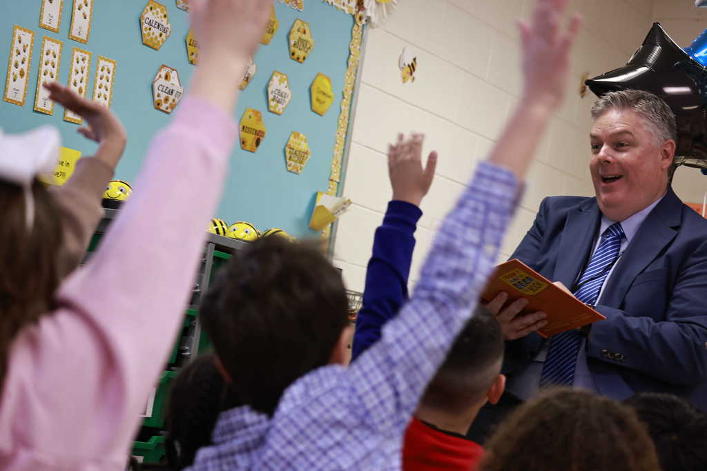 Dr. Cotton laughs as student empathically raise their hands to answer a question