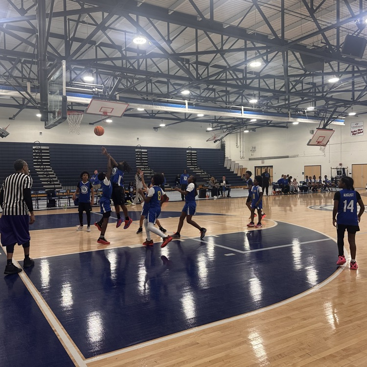 SRI and CAR basketball team on the court in the middle of an exciting  shot. 
