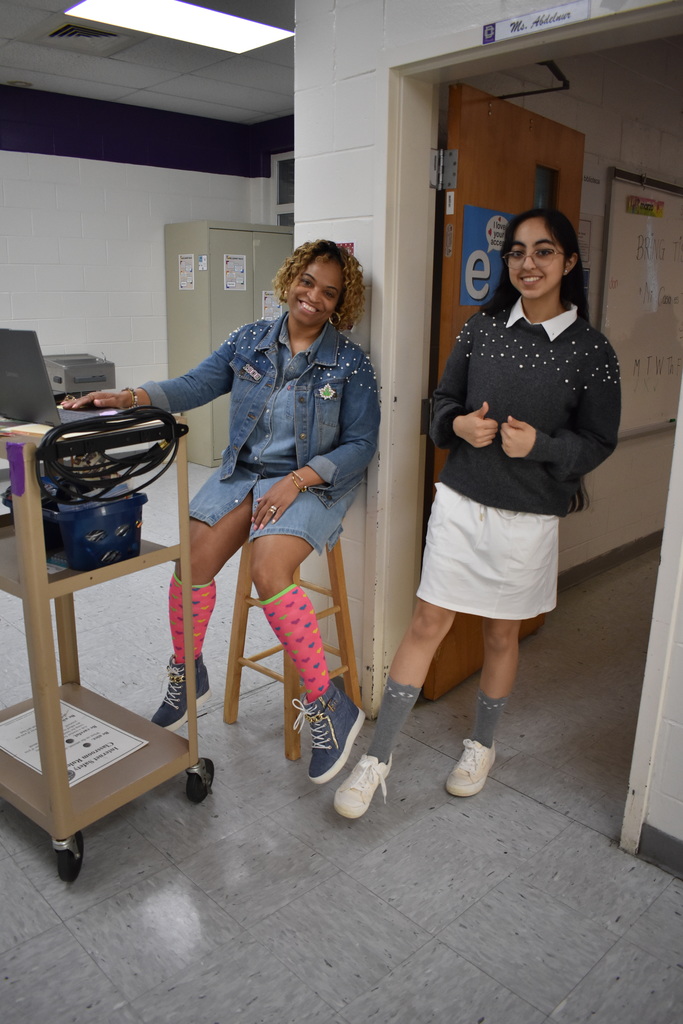 A student and a teacher showing off their fun socks