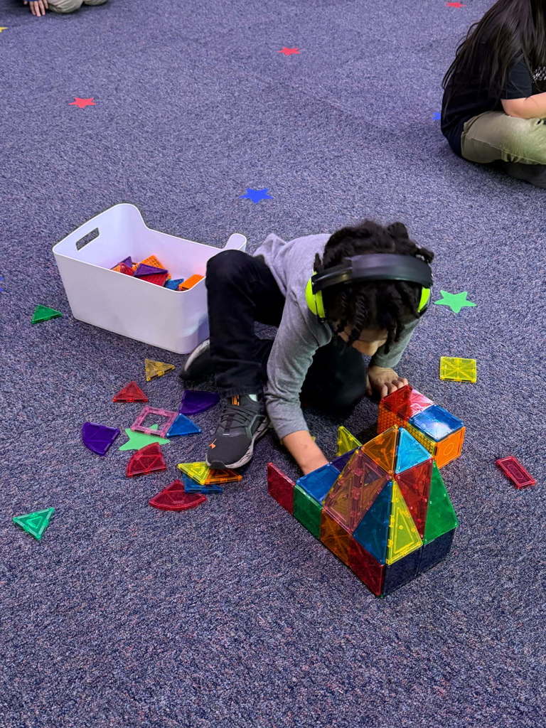 student building a basketball arena with magna tiles