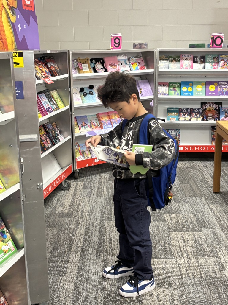 Student reading a book at the book fair.