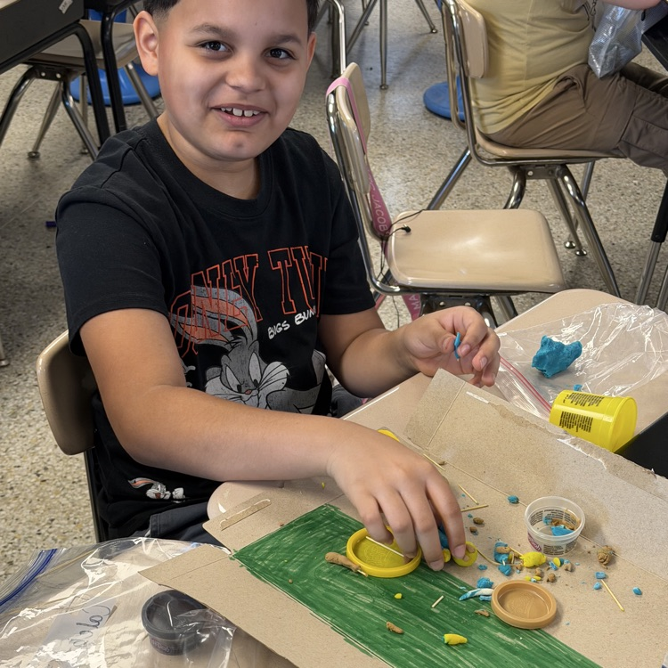 student excited to make their clay model.