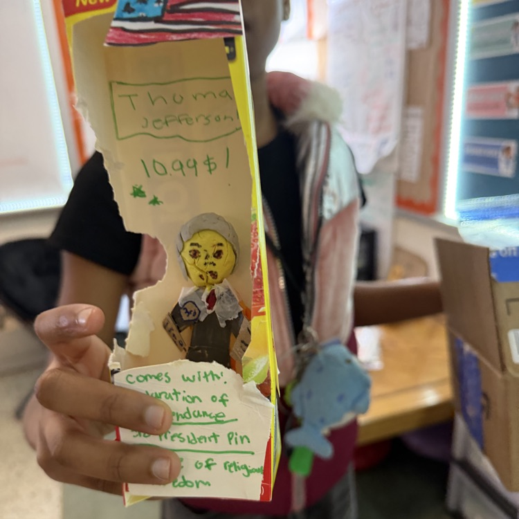 student holding up finished action figure.