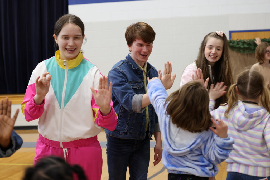 Students are excited about the performance . High Fives all around!