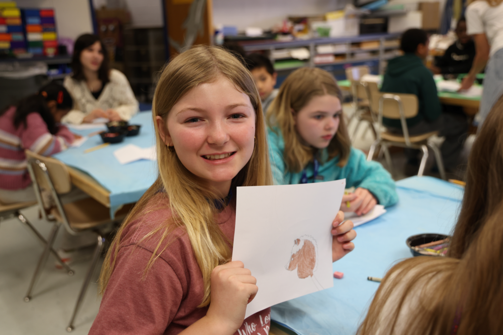 Student proudly sharing her artwork