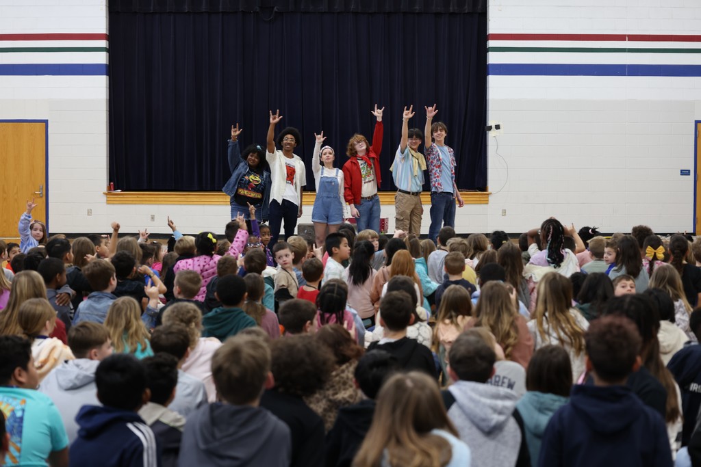 students cheer as the performers pose for the  final moment of the show
