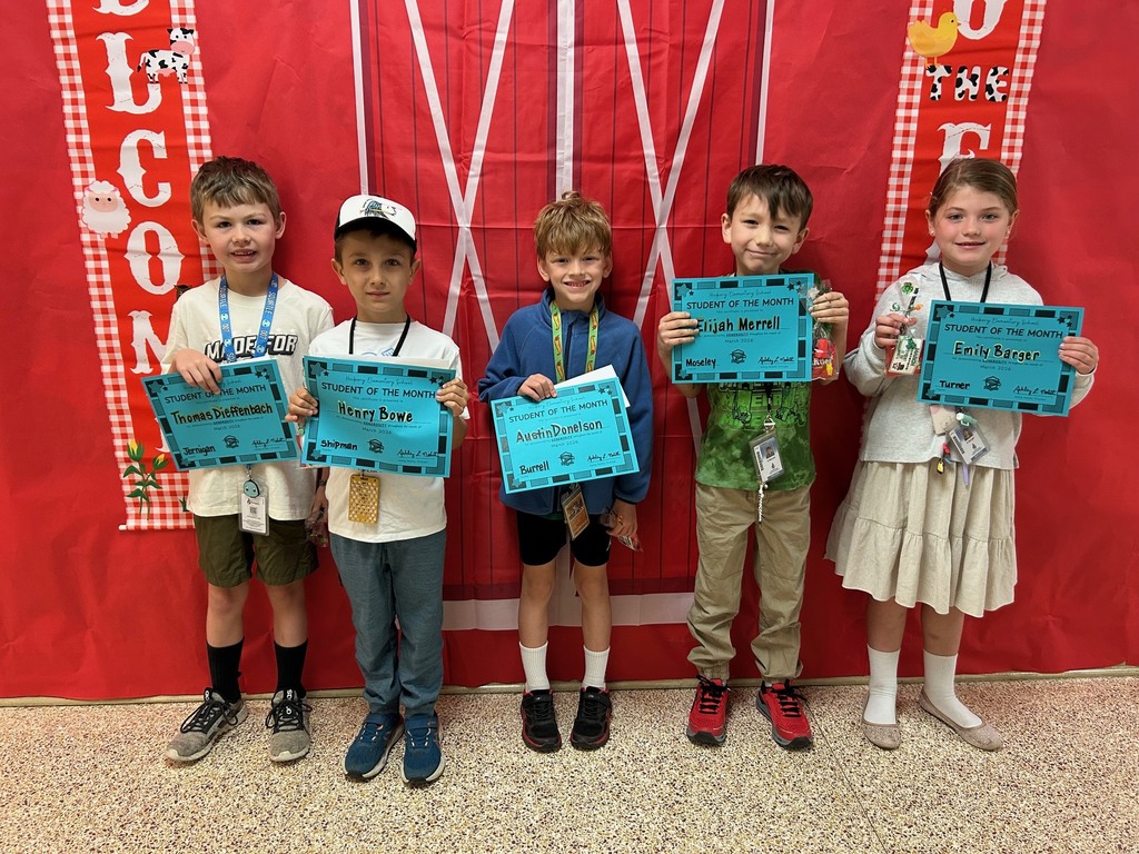 second grade students holding their student of the month awards