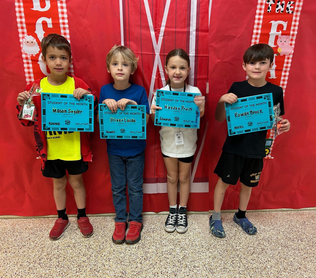 first grade students holding their student of the month awards