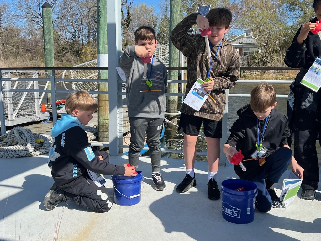 students testing water on the learning barge