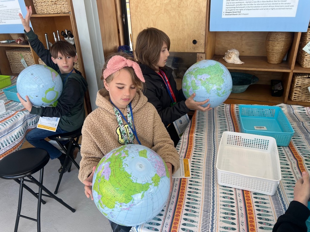 students learning with globes on the learning barge