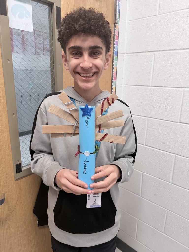 A smiling student showing his hand made creation