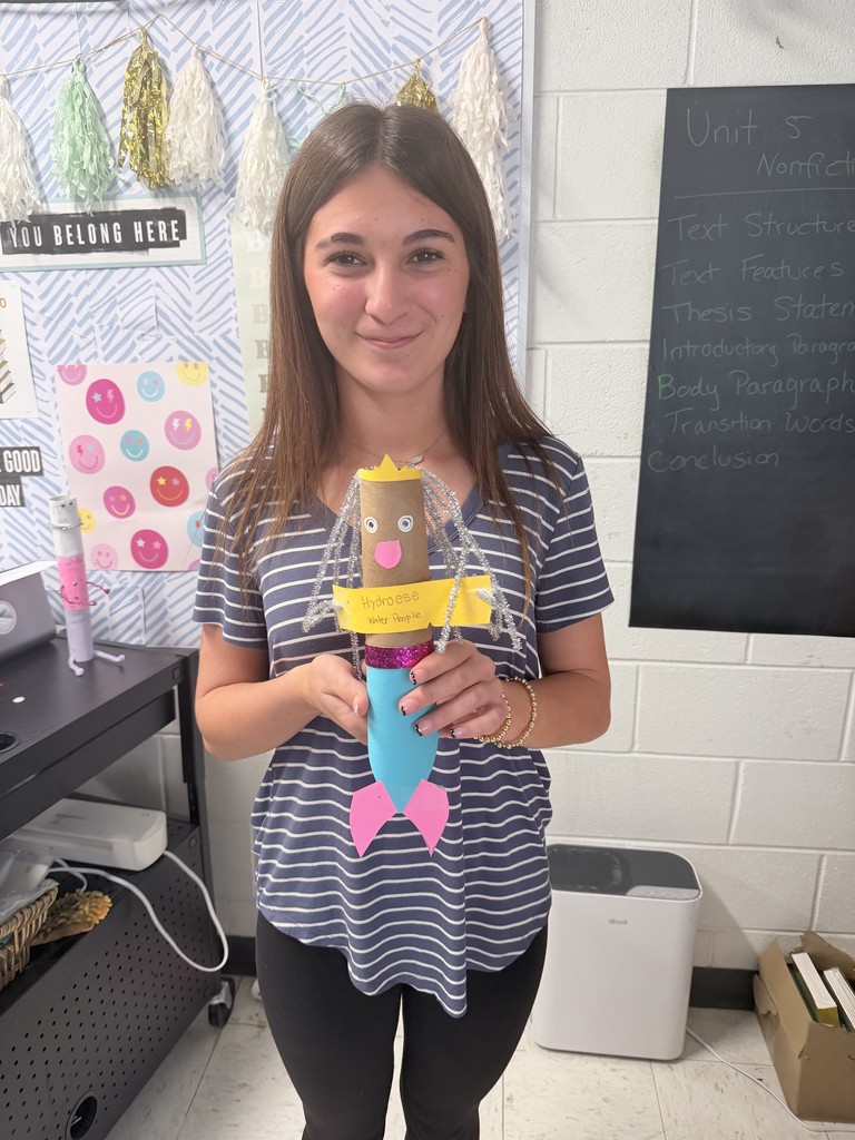 A student proudly displaying her hand made creation