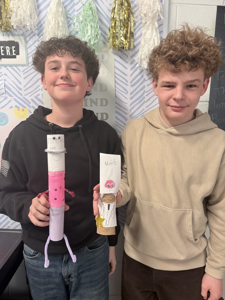 Two students proudly showing their hand made creations