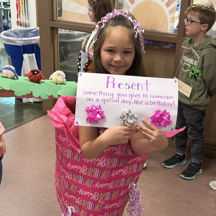 student dressed as a gift excitedly showing off her vocabulary word “Present” 