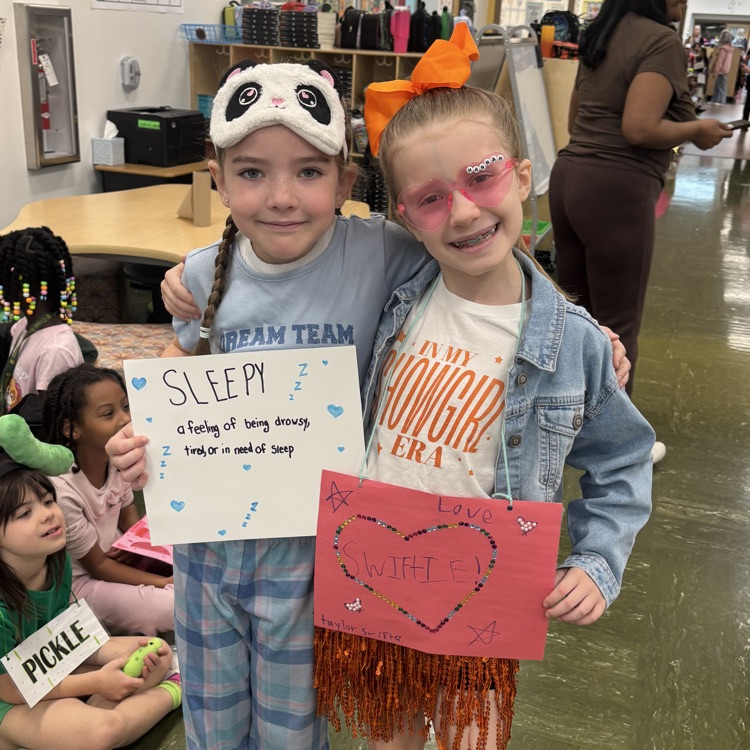 two girls excitedly posing before the vocabulary parade 