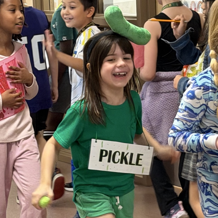 student dressed as the word pickle laughing as she walks in the vocabulary parade
